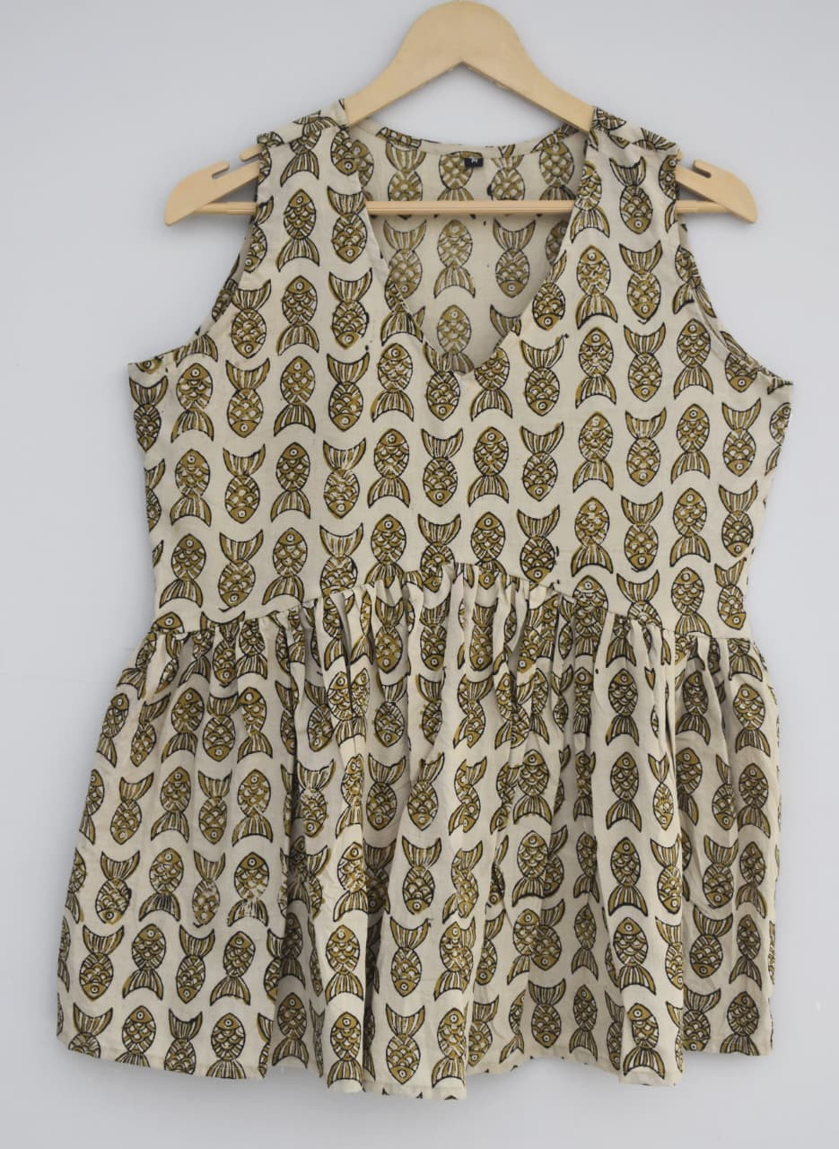 off-white or cream-colored, hand-block printed, cotton, sleeveless peplum top with a mustard yellow/olive green fish pattern