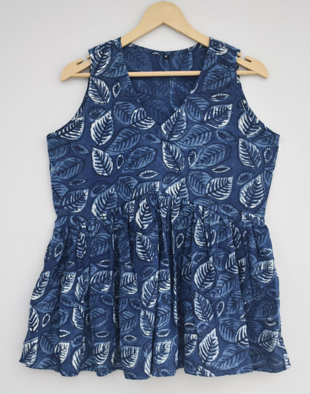 blue hand-block printed cotton sleeveless peplum top with a white leaf pattern