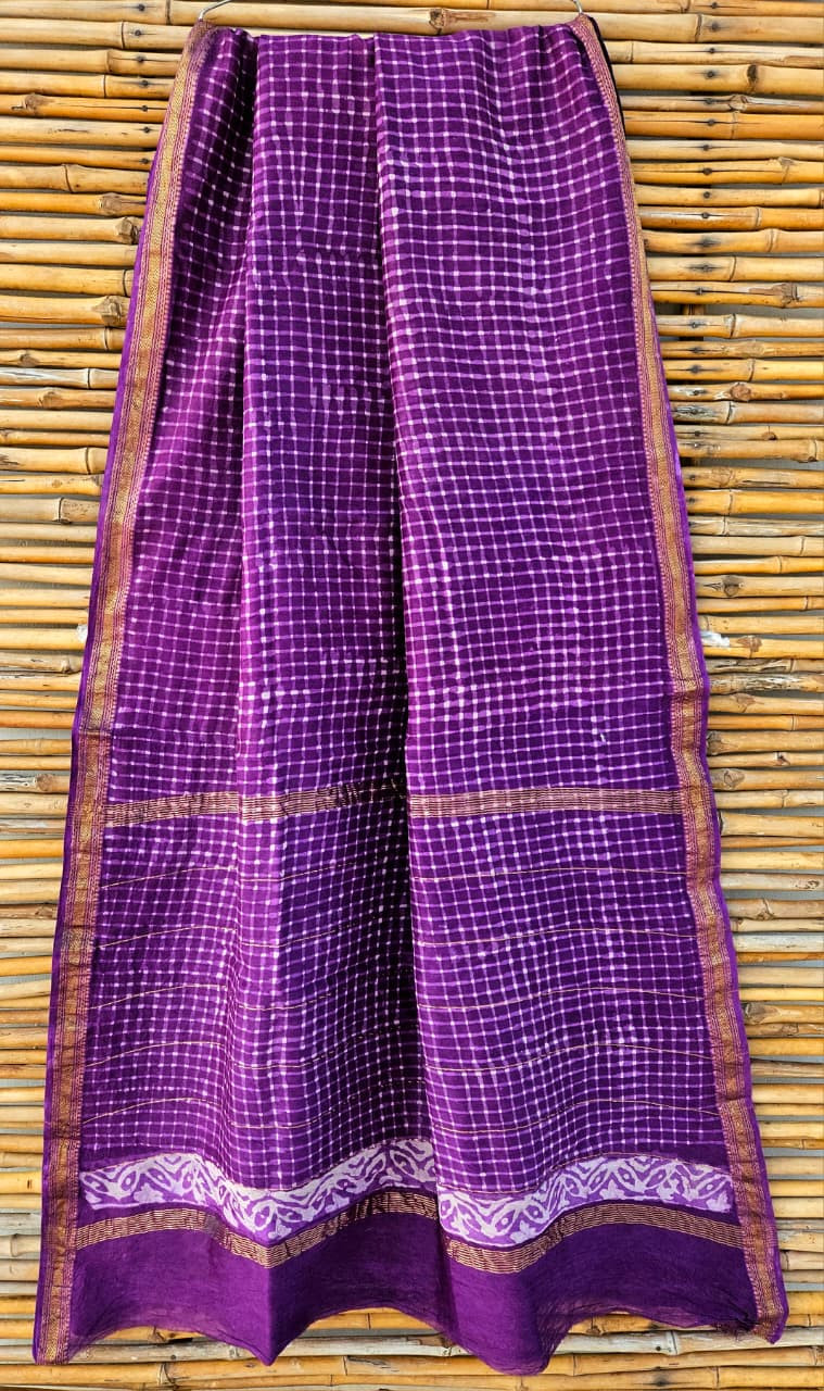 purple Maheshwari silk/cotton blend tie-dye (shibori) saree with a white checkered pattern and a golden zari border.