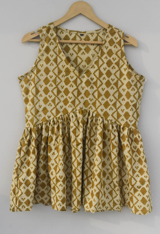 Mustard yellow, hand-block printed, cotton, sleeveless peplum top with a geometric or Aztec pattern