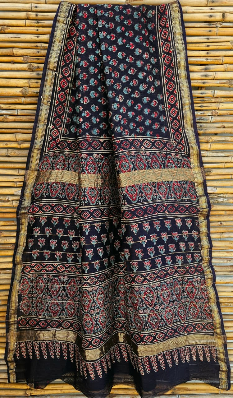 black Maheshwari silk cotton blend saree featuring traditional red and blue hand-block prints, finished with a golden zari border.