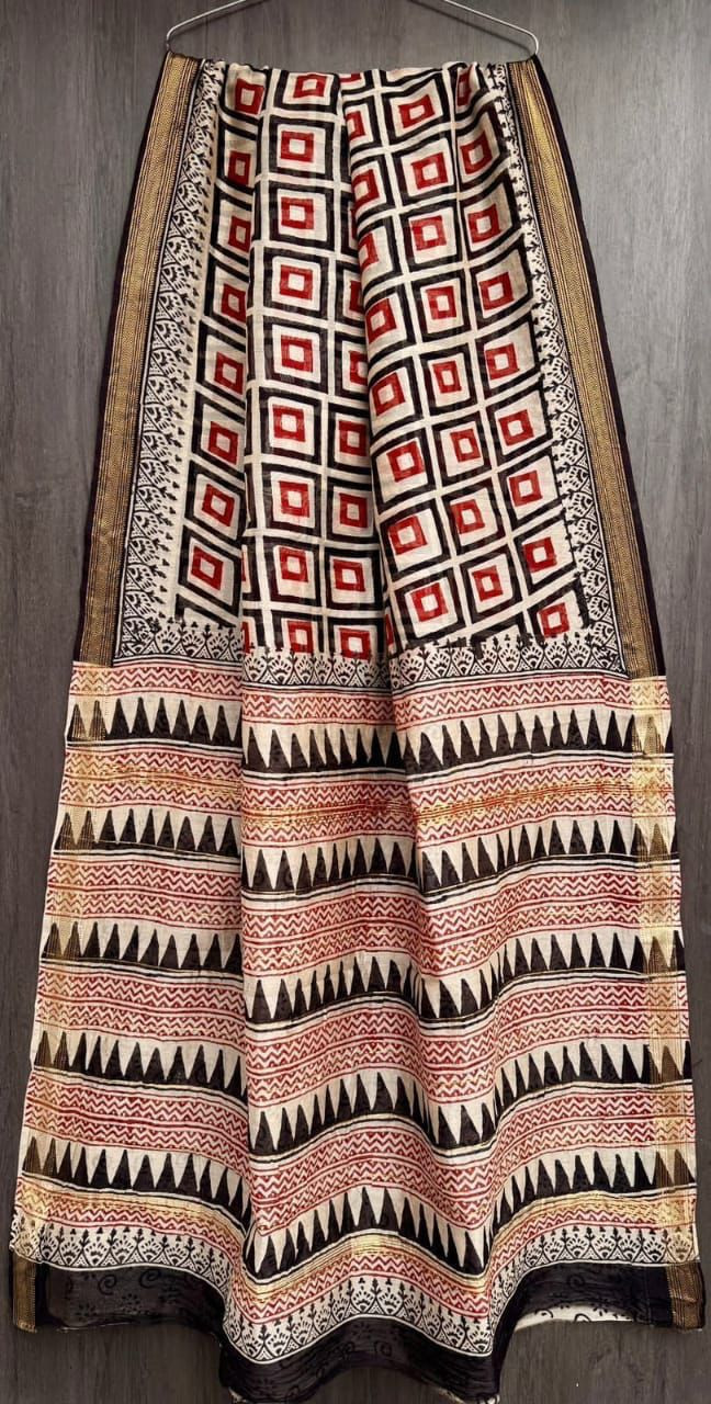 hand-block printed Maheshwari silk/cotton blend saree with geometric patterns in white, black, and red, finished with a golden zari border
