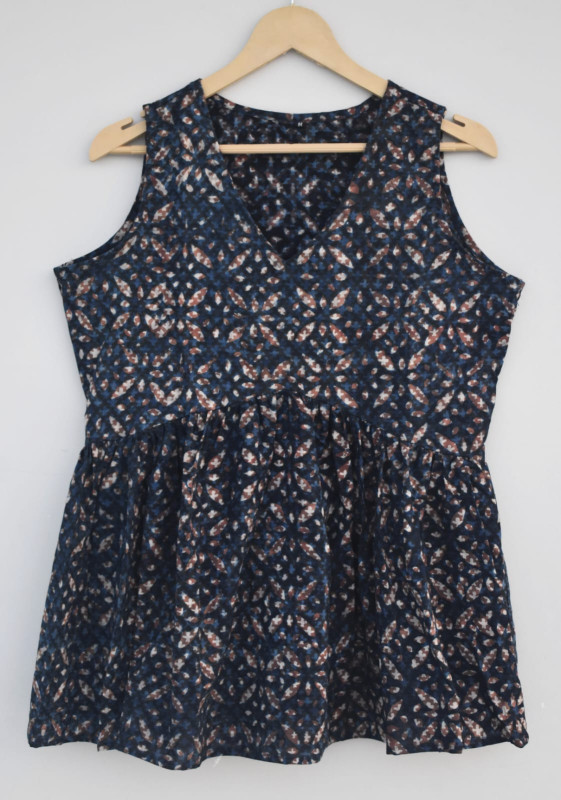 dark blue, abstract or geometric pattern, cotton sleeveless peplum top with hints of white and reddish-brown colors.