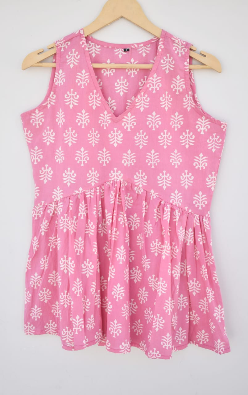pink, hand-block printed, cotton, sleeveless peplum top with a white ethnic or paisley pattern.