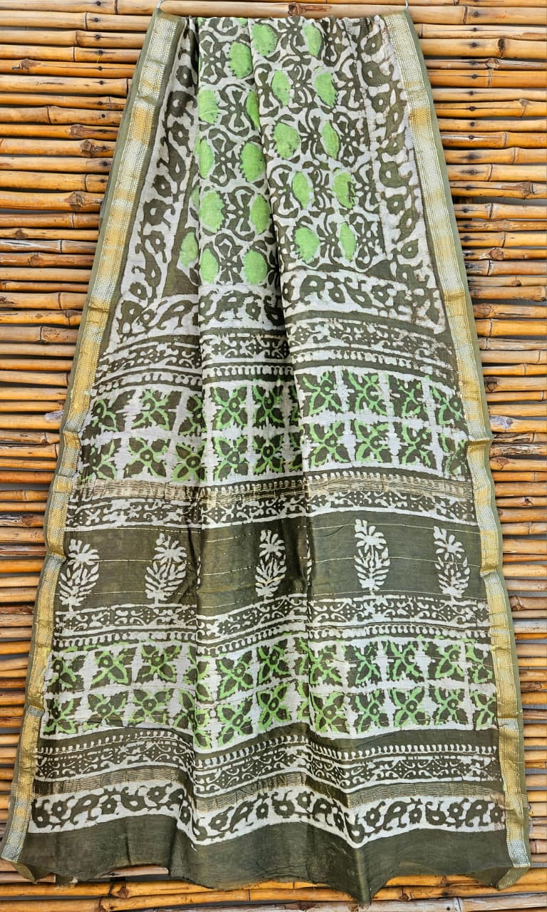 green and white hand-block printed Maheshwari or Chanderi silk/cotton blend saree with traditional motifs and a golden zari border