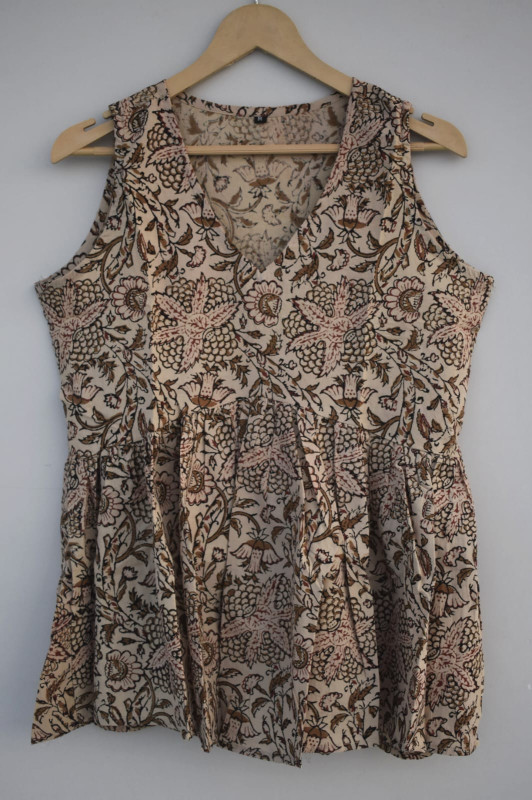 a beige, brown, and pink hand-block printed, floral or leaf pattern, cotton sleeveless peplum top
