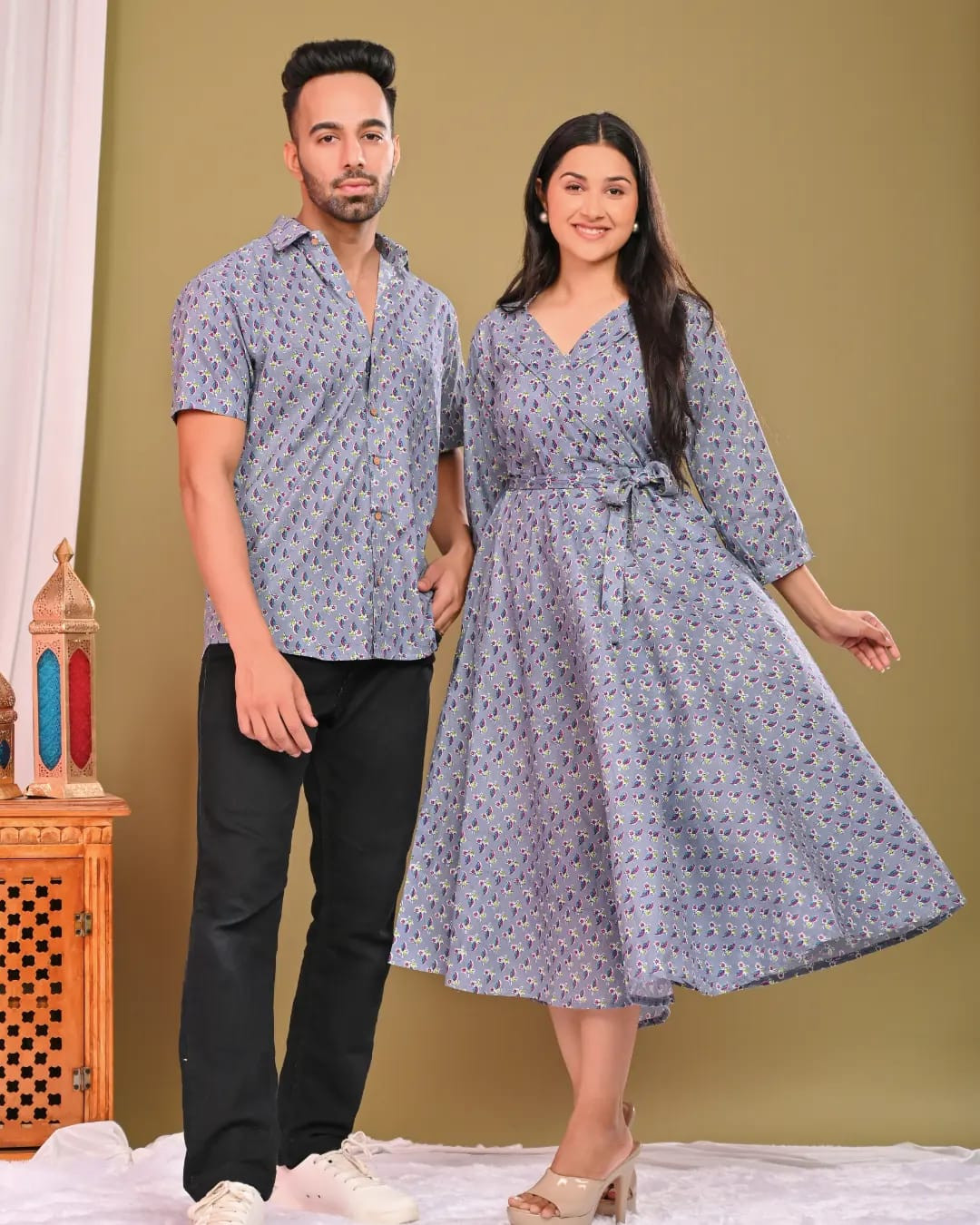 A matching couple's outfit in a blue and off-white floral/traditional block print design, made from a cotton material